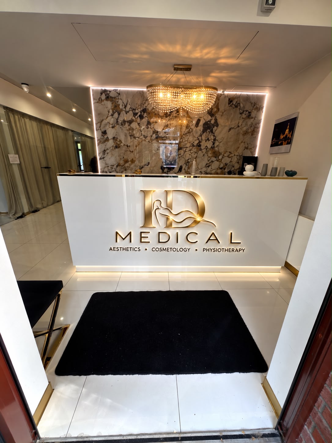 Recepcja ID MEDICAL ze złotym logo i marmurową ścianą